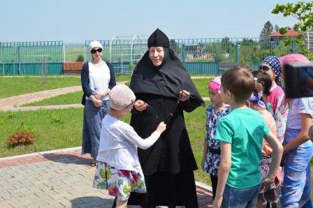 Монахиня рассказывает о четках и дает детям их потрогать.